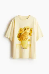 Remera color crema de corte amplio con estampado de girasoles en un jarrón y la firma 'Vincent'.