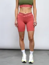 Calza corta de lycra color salmón con cintura alta con elástico con logo Umbro.