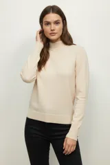 Polera de tejido de punto color beige claro, de manga larga y cuello alto tipo tortuga.