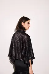 Camisa negra con estampado de hojas en relieve, cuello camisero, mangas anchas y corte cropped.