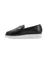 Mocasín de cuero negro con perforaciones decorativas y suela blanca de plataforma.