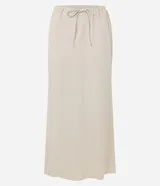 Conjunto color beige compuesto por una falda midi de lino y viscosa con lazo en la cintura y un chaleco sin mangas con botones. Incluye un bolso tote beige.