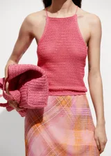 Top tejido al crochet color rosado, con cuello halter y tirantes finos.