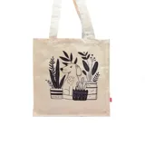 Bolso tipo tote bag color crudo con asas de tela y estampado de un perro y plantas en macetas.