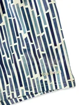 Short de baño blanco con estampado de hojas de palmera en tonos verde, rojo y amarillo.