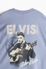 Remera celeste de corte amplio con cuello redondo y estampado pequeño en el pecho.