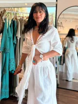 Top blanco de algodón con escote en V, mangas 3/4 y cierre con lazo en el frente.