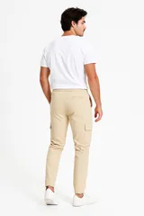Pantalón cargo color gris topo, con cintura elástica ajustable con cordón, bolsillos laterales con solapa y puños elásticos. Corte slim fit.