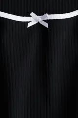 Vestido mini negro de manga corta en punto de algodón acanalado con pollera evasé. Modelo con cuerpo entallado y escote redondo amplio con ribete fino blanco y moña decorativa de satén. Ribete sobrehilado en mangas y bajo.