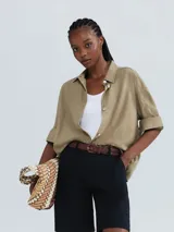 Musculosa slim color ocre, de tela acanalada con cuello redondo y sisas anchas.