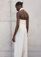 Top blanco de punto fino con cuello halter y diseño entallado.