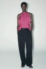 Top color fucsia de cuello halter con volantes en el mismo tejido. Cierre en la espalda con abertura y botones.