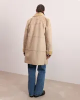 Chaqueta de lana color beige con cuello de pelaje y cierre frontal.