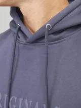 Hoodie tipo canguro azul con capucha y cordones ajustables. Estampado con la palabra "Originals" y el logo de Jack & Jones en el pecho.