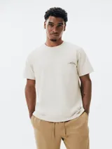 Remera color beige de algodón con bolsillo en el pecho y bordado de montañas.