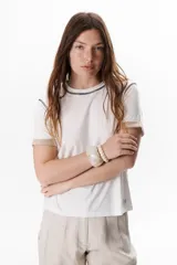 Remera blanca de manga corta con cuello redondo y detalle de costuras en contraste en cuello y mangas.