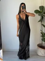 Vestido largo negro con breteles finos, escote en V y detalles de encaje en el escote y en el ruedo.