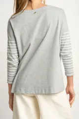 Sweater oversize gris con rayas horizontales blancas, de tejido suave y mangas largas.
