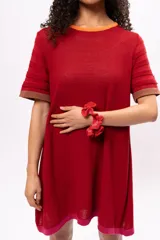 Vestido corto tipo remerón de manga corta, color rojo con cuello y puños en marrón y ruedo en fucsia.