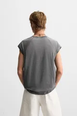 Musculosa gris de corte holgado con cuello redondo y sisas amplias. Tiene un efecto lavado que le da una apariencia única.