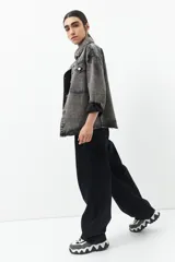 Jean ancho de tiro bajo con tira ajustable y hebilla trasera, ideal para un look moderno y cómodo.
