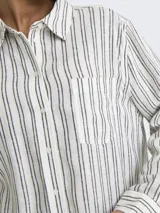 Camisa de lino y viscosa blanca con finas rayas verticales en color negro/gris oscuro. Presenta cuello clásico, bolsillo de parche en el pecho y cierre frontal de botones.