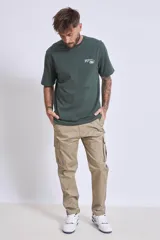 Remera de manga corta color verde oscuro, con cuello redondo y un pequeño estampado blanco en el pecho.