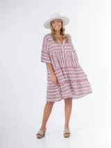 Vestido amplio con estampado abstracto en tonos rojo y blanco, cuello mao y mangas cortas.