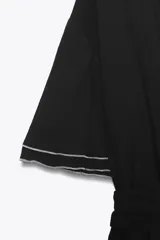 Vestido midi negro con cuello solapa, escote en V cruzado, manga corta con volantes, detalle de costuras a contraste, elástico en la cintura y cinturón ajustable con lazada.