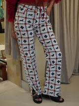 Pantalón de jean blanco con estampado de caballos negros, estrellas azules y motivos geométricos en naranja. Corte recto con aberturas en el ruedo.
