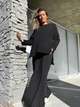 Conjunto negro compuesto por un remerón oversize de mangas largas y un pantalón palazzo de tiro alto con elástico en la cintura.
