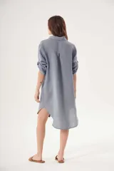 Vestido camisero blanco de lino, con cuello clásico, cierre frontal con botones y mangas 3/4 con trabillas.