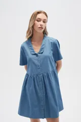 Vestido corto camisero de denim celeste, con cuello camisero, mangas cortas y falda acampanada con botones frontales.