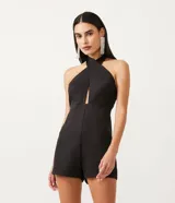 Mono corto negro de sastrería en crepé, con escote halter cruzado, busto marcado y abertura en el abdomen.