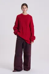 Sweater rojo de punto grueso con trenzas y rombos en relieve.