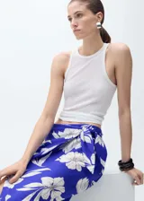 Falda midi de viscosa color azul con estampado floral blanco, de corte recto y tiro medio, con detalle de nudo en la cintura y goma elástica.