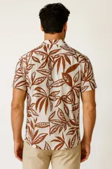 Camisa de viscosa con estampado de hojas de palmera en tonos azul y blanco, con cuello clásico y manga corta.