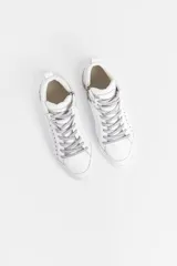 Zapatilla tipo botita de cuero negro con recortes de glitter negro y reptil, detalle de remaches metálicos y acceso lateral con cierre.