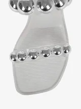 Sandalias bajas negras de PVC con dos tiras horizontales adornadas con apliques esféricos plateados.