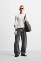 Pantalón de jean celeste con efecto lavado, corte amplio tipo baggy y cinco bolsillos.