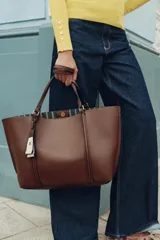 Bolso negro tipo shopper con asa de hombro, detalle de colgador y bolsillo interior maxi. Cierre mediante imán.