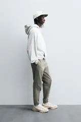 Pantalón jogger negro de corte slim fit, confeccionado en tejido de algodón con cintura elástica ajustable con cordón, bolsillos frontales y traseros de vivo, y bajo con puño elástico.