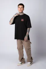 Remera blanca de algodón de corte oversize con mangas cortas y cuello redondo. Presenta un pequeño estampado en el frente con la figura de Mickey Mouse y caracteres orientales.