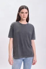 Remera gris oscuro con cuello redondo y tachas plateadas alrededor del cuello.
