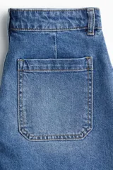 Short de denim de algodón levemente elástico con bolsillos parche delanteros y traseros. Modelo de tiro alto con cierre y botón.