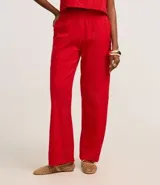 Pantalón recto de cintura alta confeccionado en laise rojo con textura de perforaciones.