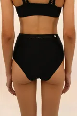 Calzón de bikini negro de tiro alto con detalle de calado geométrico en la cintura.