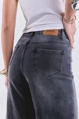 Pantalón de jean negro gastado, de tiro alto y corte wide leg.