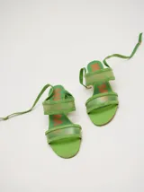 Sandalias de gamuza color negro con tiras transparentes de poliuretano, taco redondo y tiras finas al tobillo.