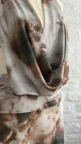 Vestido largo de microtul con estampado tie-dye en tonos rosa, verde y gris. Diseño con escote halter y espalda descubierta.